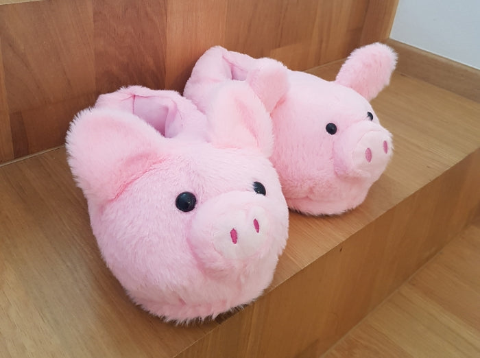 Plush pig slippers placed on stairs.
